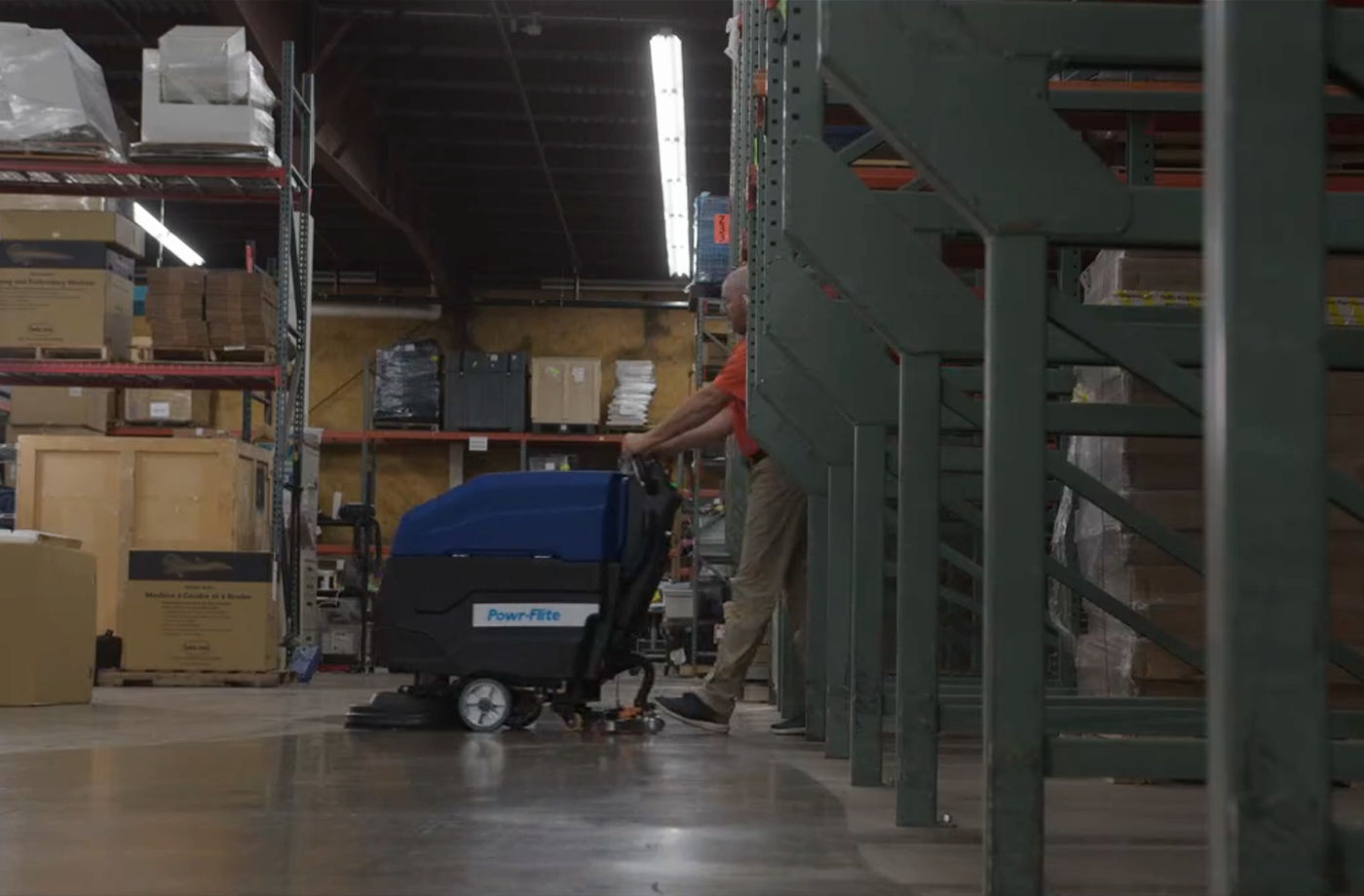 Industrial warehouse floor scrubbing with commercial equipment